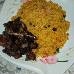 A picture of Jollof rice, with roasted meat.
