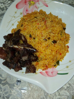 A picture of Jollof rice, with roasted meat.