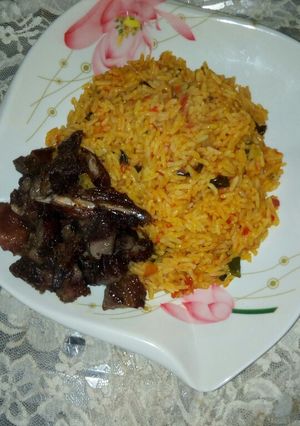 A picture of Jollof rice, with roasted meat.