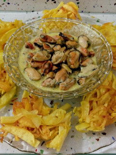 Una foto de Nidos de patatas fritas y mejillones en salsa
