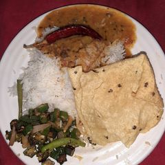 A picture of Dal fry fried bhindi papad and plain rice.