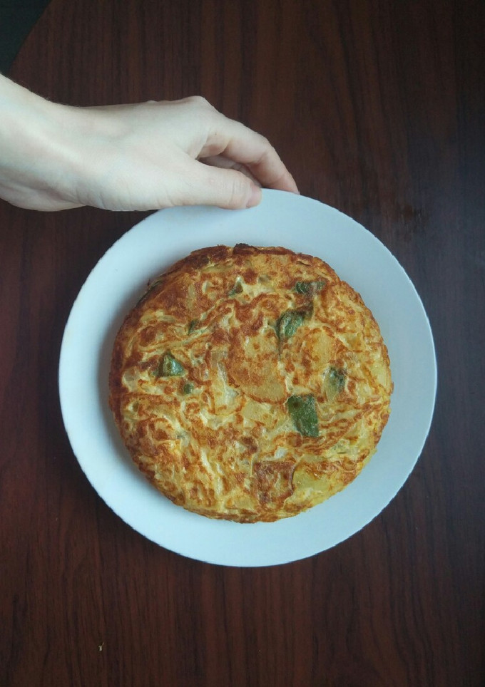 Una foto de Tortilla de patatas con cebolla y pimiento verde