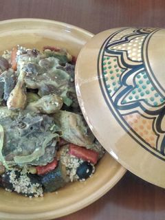 Una foto de Cous-cous de cordero, pollo, legumbres, frutos secos y verduras