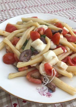 A picture of Pasta mozzarella, tomatoes and olives.