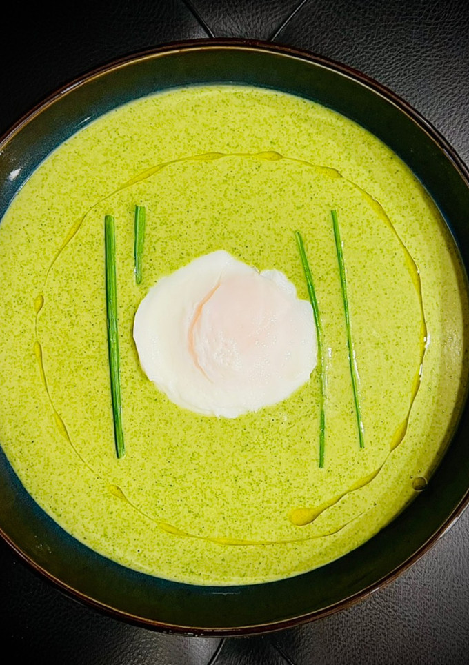 Una foto de Crema verde de lechugas y caldo de ave con huevo poché