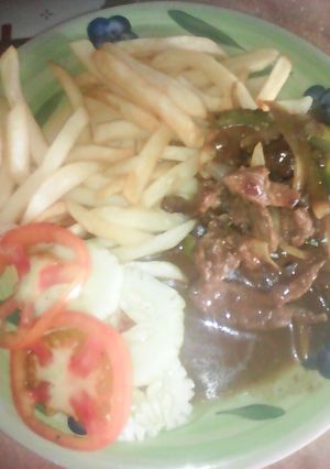 Una foto de Bistec picado acompañado con papas fritas y ensalada