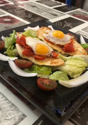 Una foto de Milanesa de pollo con cama de ensalada pimientos asados y huevos de codorniz