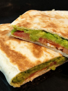 Una foto de Tortilla de trigo rellena de aguacate, tomate y queso