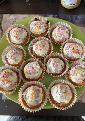 A picture of Strawberry cupcakes with vanilla frosting and sprinkles.