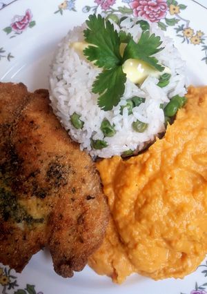 Una foto de Puré de camote con pescado frito y arroz, blanco con alverjitas🇵🇪