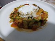Una foto de calabacin frito con tomate