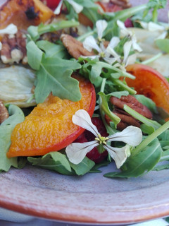 Una foto de Ensalada de hinojo y frutas con flores de rúcula
