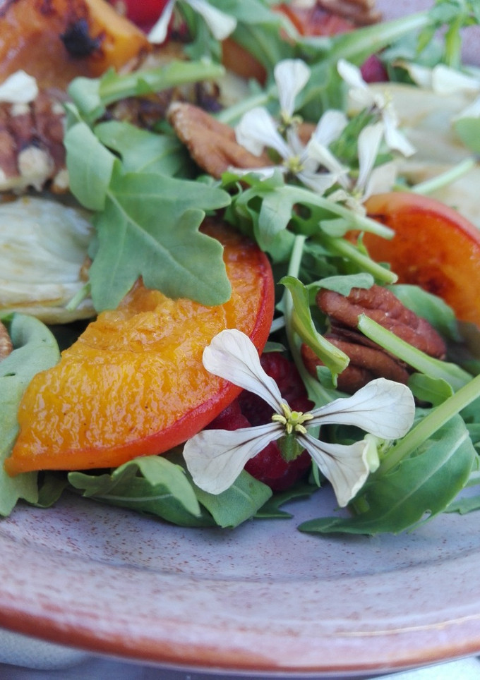 Una foto de Ensalada de hinojo y frutas con flores de rúcula