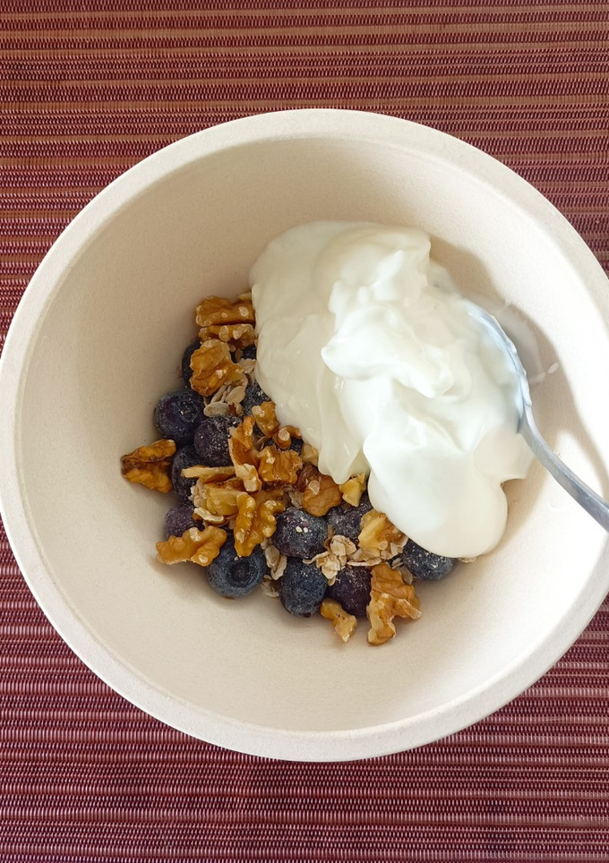 Una foto de Bol de yogur griego, arándanos, copos de avena y nueces