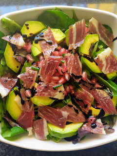 Una foto de Ensalada de aguacate, jamón ibérico y granada