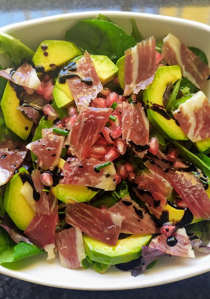 Una foto de Ensalada de aguacate, jamón ibérico y granada