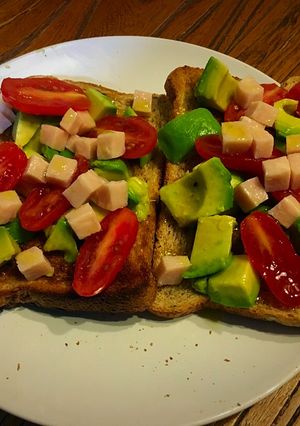 Foto principal de Tostadas de pan con semillas de sésamo y lino, aguacate, tomates y pavo