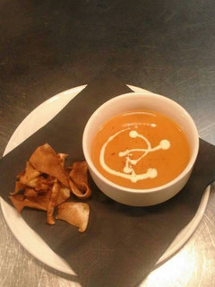 A picture of Cream of tomato soup with parsnip crisps.
