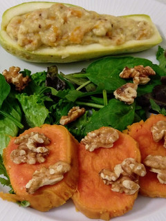 Una foto de Calabacines rellenos de calabaza frita y ensalada de brotes con batatas y nueces