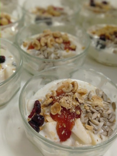 Una foto de Postre de yogurt con mermelada y frutas, adornado con avellanas