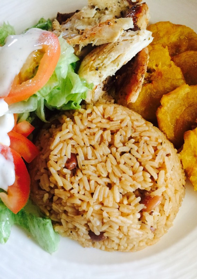 Una foto de Moro de habichuelas con pollo, fritos y ensalada verde