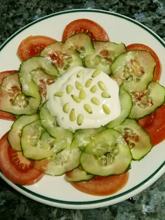 Una foto de Ensalada de pepino marinado, salsa de yogur, tomate y piñones
