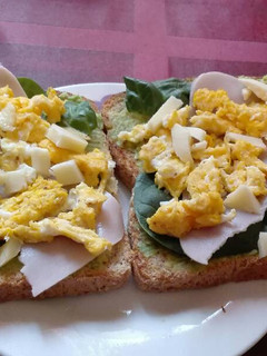 Una foto de Tostadas untadas con aguacate, espinaca, pavo y huevo revuelto