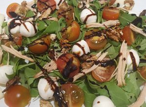 Una foto de Ensalada de rúcula, cherry, queso, nueces, mozzarella y pollo