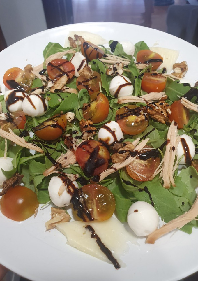 Una foto de Ensalada de rúcula, cherry, queso, nueces, mozzarella y pollo