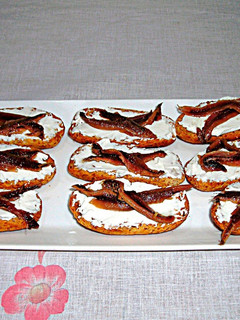 Una foto de Tapitas de anchoas y queso crema sobre rebanas de pan tostado