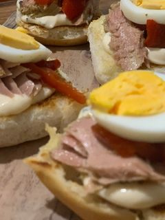 Una foto de Brioche tostado, mayonesa de albahaca, tronco de atún, pimiento asado y huevo