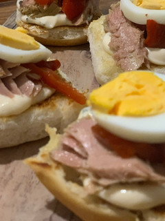 Una foto de Brioche tostado, mayonesa de albahaca, tronco de atún, pimiento asado y huevo