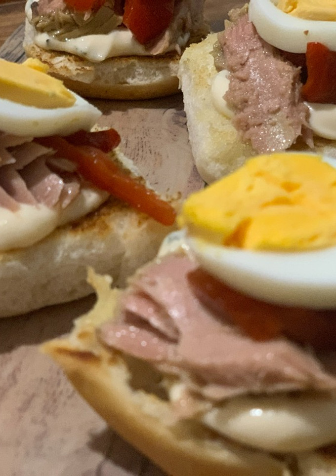 Una foto de Brioche tostado, mayonesa de albahaca, tronco de atún, pimiento asado y huevo