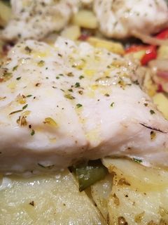 Una foto de Pescado al ajo y orégano en cama de patatas con sorpresa