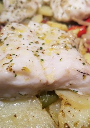 Una foto de Pescado al ajo y orégano en cama de patatas con sorpresa