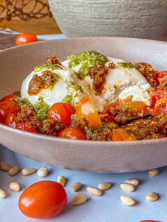 Una foto de Burrata con cherrys asados y pestos