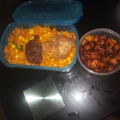 A picture of Jollof rice with fried plantain and chicken.