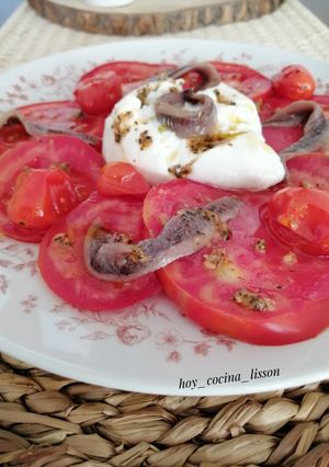 Una foto de Ensalada de tomate, burrata y anchoas