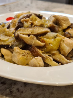Una foto de Pollo encebollado con setas y calabacín