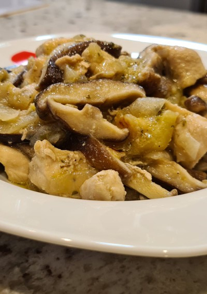 Una foto de Pollo encebollado con setas y calabacín