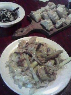 Una foto de Chop suey dorado acompañado de papas rusticas sobre un salteado de berenjenas y cebollas (Brillo de luna)