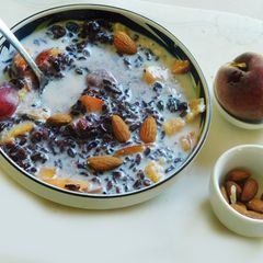 A picture of Black rice porridge with fruits and nuts.