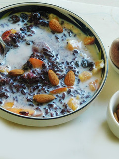 A picture of Black rice porridge with fruits and nuts.