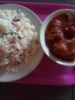 A picture of White Rice mixed with Beans and diced plantain with stew.
