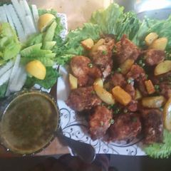 A picture of Fish fry with wedges and peas.
