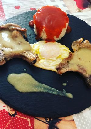 Una foto de Plato combinado arroz blanco tomate, huevo frito y chuletas en salsa de almendra