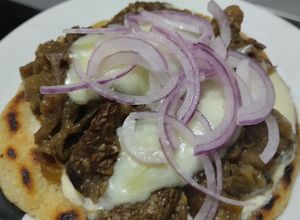 Una foto de Arepa🫓con berenjenas tatemadas🍆agridulces🍯con queso🧀🥛🧄