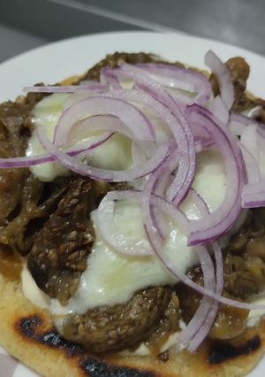 Una foto de Arepa🫓con berenjenas tatemadas🍆agridulces🍯con queso🧀🥛🧄