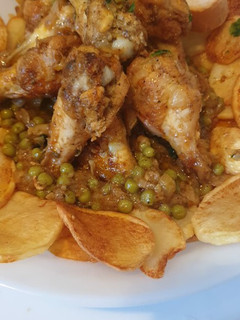 Una foto de Pollo al ajillo con patatas y guisantes