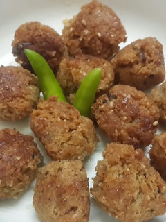 A picture of Til narkol postor bora (Sesame coconut and poppy seed fritters).